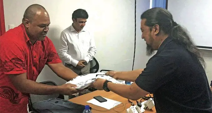 Fiji Sun Managing Editor Design Naisa Koroi presents Roshan Tamang a Flying Fijians jersey during the farewell for the trainers from Asia Media Design. Centre: Asia Media Design head and founder Jai Kumar Sharma. Photo: Ilaijia Ravuwai