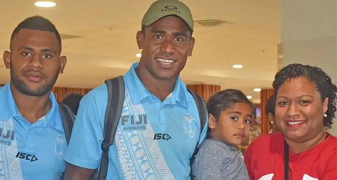 From left: Vilimoni Botitu and Aminiasi Tuimaba with a Fijian 7s fan at the Nadi International Airport on May 15, 2019. Photo: Mereleki Nai