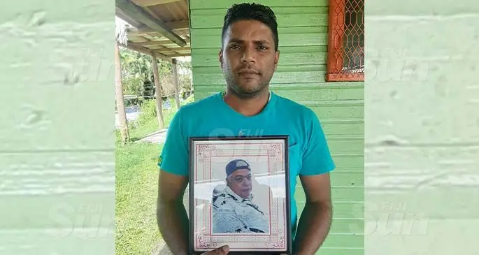Mohammed Iftikar Ali holding a photo of his late grandfather Ashrat Ali Razat. Photo: Shreeya Verma
