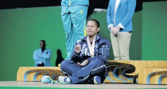 Eileen Cikamatana accepts her gold medal at the Commonwealth Games in the traditional iTaukei manner.