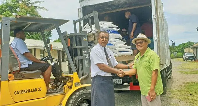 Food with Love Mission Fiji group president Paul Kim (right) delivers relief supplies for victims of Cyclone Yasa. 