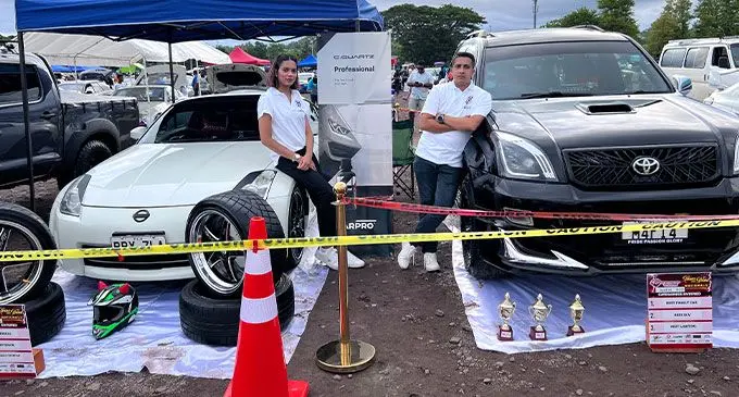 Rizwan Buksh and his wife Gazala in front of their cars at a recent road show.