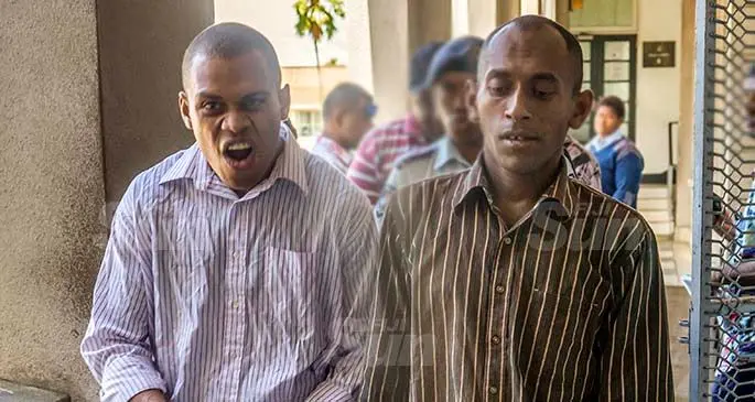 Tevita Badogo (left) and Eroni Bale are being led by Police officers after their court hearing in Suva on January 20, 2021. Photo: Leon Lord