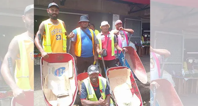 Jone Bogitini (sitting in front) and Apenisa Raloka (standing second from left) with some wheelbarrow boys at the Suva Municipal Market.