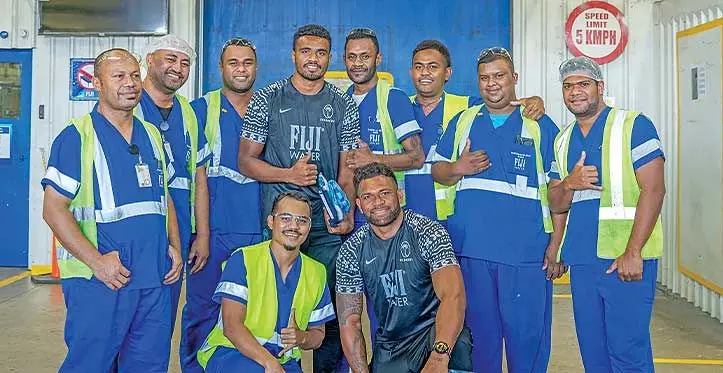 FIJI Water Flying Fijians players Seta Tamanivalu and Iosefo Masi with workers of the FIJI Water plant.