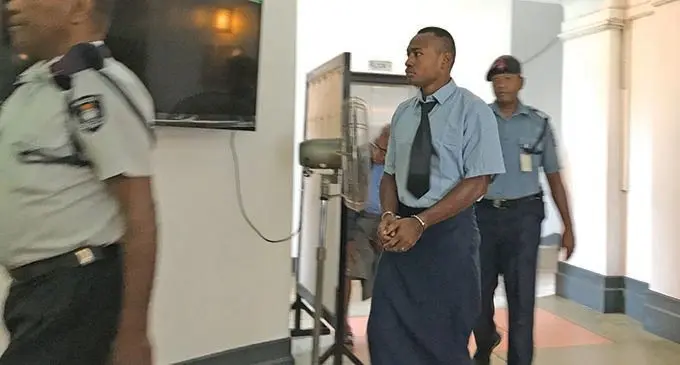 Tevita Veicavuyaki Kunawave escorted by Police outside the High Court in Suva.  