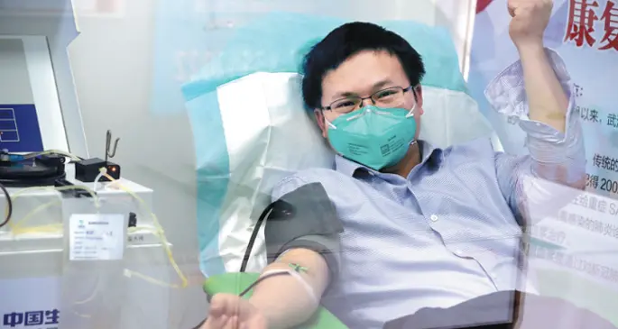 Zhang Zhengle, a 31-­year­-old man who has recovered from novel coronavirus pneumonia, donates plasma at Hubei General Hospital in Wuhan, Hubei province, on Sunday. Scientists are trying to cure patients infected with the disease using blood plasma collected from people who have recovered.Their plasma contains antibodies that may help patients develop immunity. ZHU XINGXIN / CHINA DAILY