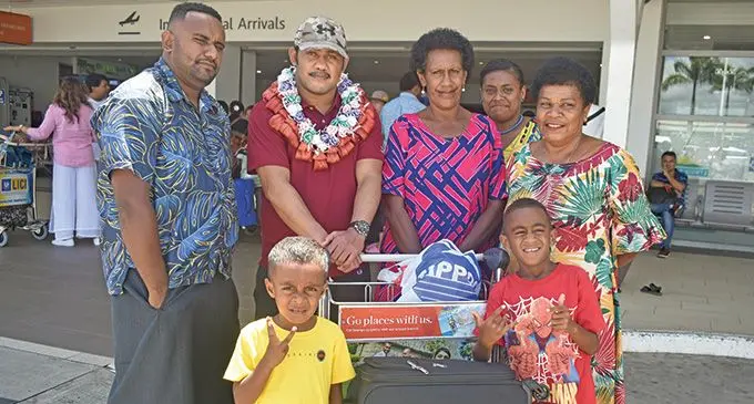 Isireli Masi (in garland) with his mother, Laniana Ruve (pink dress) with family members at the Nadi International Airport. Photo: Mereleki Nai