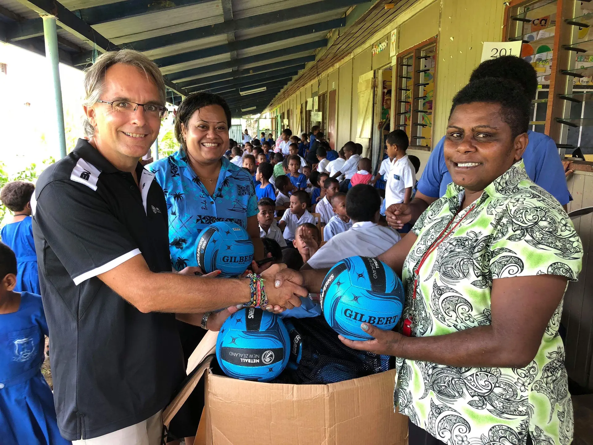 New Zealand Netball Pacific Sports in Partnership coordinator Ivan Harre (left) hands out NetGo kit to teachers at John Wesley Primary School in Raiwai, Suva. Photo: NetGO 