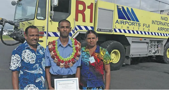 Adarsh Chand is flanked by dad Pravind Chand, and mum Shashi Kala during the graduation ceremony at the Nadi International Airport on Friday. Photo: Waisea Nasokia