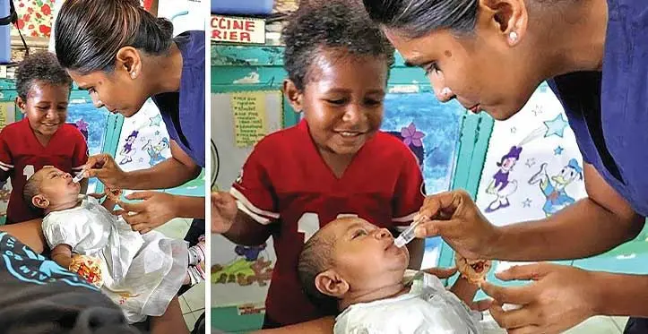 Poonam vaccinates six-week-old Seini, as her brother looks on.