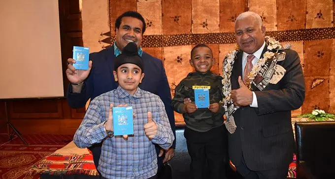 Akuila Cakacaka (back left), Akjot Singh and George Jioji (receiving the passport on behalf of Elnathan Cakacaka), with Prime Minister Voreqe Bainimarama.   Photo: Office of the Prime Minister
