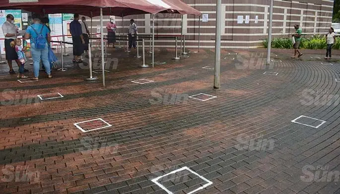 Fiji National Provident Fund Plaza staff, in Suva assists people with their quarries while practicing social distancing at the time on March 31, 2020. Photo: Ronald Kumar.