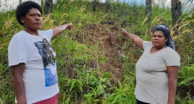 Mererai Sese (left) and Aseri Savui (right) point to the slope where six-year-old Grace Tuinasolo fell from on May 15, 2020. Photo: Nicolette Chambers  