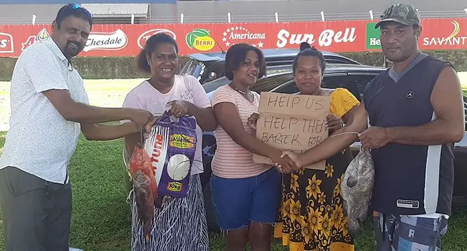 Lautoka Residents and Ratepayers Association member Narayan Reddy (left) and Ana Masere (second from right) barter fish for clothes from Raijieli Lakena (second from left) and Ecelina Tamani (third from left) in Navutu, Lautoka, on May 28, 2020. On the far right is Wili Drasuna. Photo: Salote Qalubau