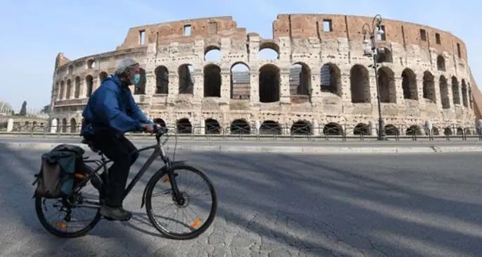 A man wearing a face mask rides a bike in Rome, Italy, March 22, 2020.(Photo by Elisa Lingria/Xinhua)