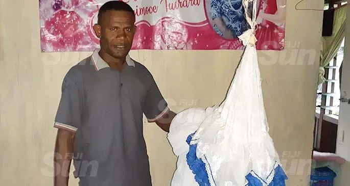 Vunivaivai headman Akuila Rawaqa showing the mosquito net they are using to have their meals under because of the fly infestation. Photo: Shalveen Chand