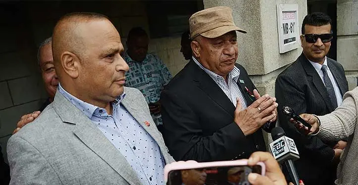 Former Prime Minister Voreqe Bainimarama (wearing hat), and suspended Commissioner of Police Sitiveni Qiliho (left) with their lawyer Devanesh Sharma, outside the Suva Magistrates Court on October 12, 2023. Photo: Ronald Kumar