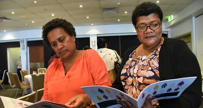 Women reading the “Business Case for Workplace Responses to Domestic & Sexual Violence in Fiji” report after its launch in Suva, last year.