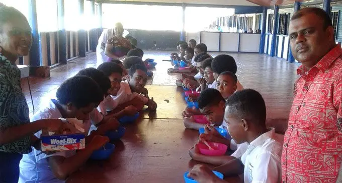 Nadogo Central College principal Mohammed Khan serves breakfast to his students. 