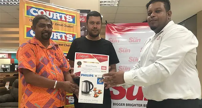 Courts retail manager Benjamin Mohammed (left), and Fiji Sun marketing manager Rajiv Raju (right) present the letter of the week award for December 2017 to Stephen Chandra on March 27, 2018. Photo: Sheldon Chanel