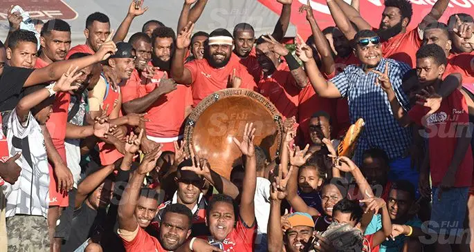 Qoibau Reds players with supporters hoist the Taukei Nagaceu Bowl at Subrail Park, Labasa on September 7, 2019. They beat Nasekula Blues 22-17 to also win $3000 prize money. Photo: Mohammed Zulfikar