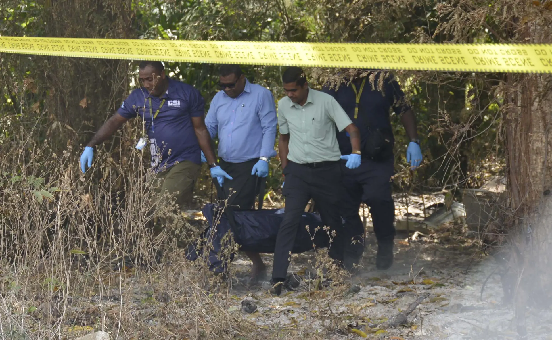 Police forensic officers carry the body of a woman found unresponsive in Martintar, Nadi.