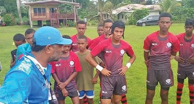 Seaqaqa Central College rugby coach and teacher Taniela Vakamoce (left) with the school rugby team.