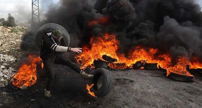 A Palestinian protester burns tires during clashes with Israeli soldiers, after a protest against the expanding of Jewish settlements in Kufr Qadoom village near the West Bank city of Nablus, on Jan. 31, 2020. (Xinhua/Nidal Eshtayeh)