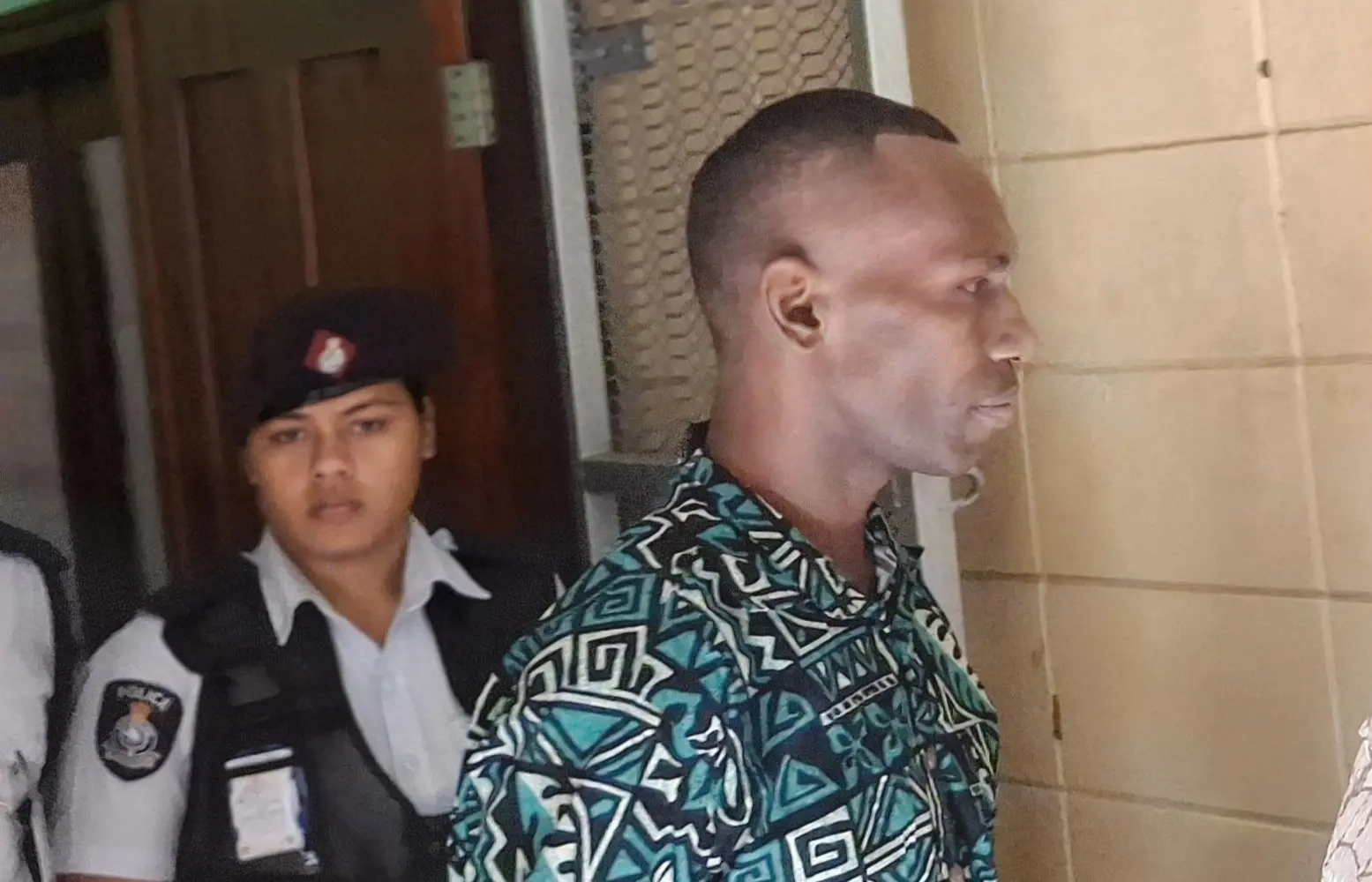 Paula Caginicolo is escorted by police officers after appearing at the High Court in Lautoka on a murder charge.