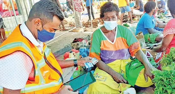 Suva City Council enforcement officer, Arvin Ram checks the vaccination card validation of Suva market vendor Elena Lewe on September 24, 2021. Photo: Ronald Kumar