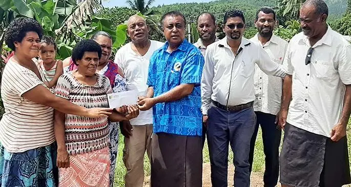 Nabou Green Energy Pte Limited general manager, Richard Yogesh Kashyap (third from right), and the Commissioner Western, Mesake Ledua, hand over a cheque to members of the Lololo community .