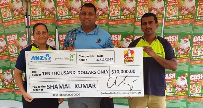 Crest Cash for Christmas promotion winner Shamal Kumar (middle) being presented with a cheque for $10,000.
