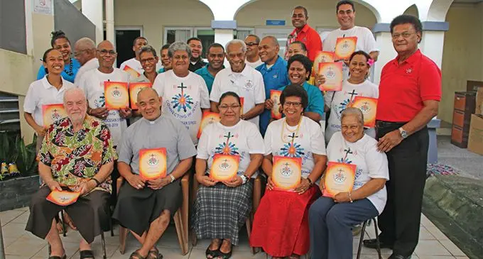Archbishop Peter Loy Chong (sitting, second from left), with members of his Curia team holding the Catholic Church Synod Commemorative magazine at Nicolas House in Suva. Photo: Catholic Church in Fiji