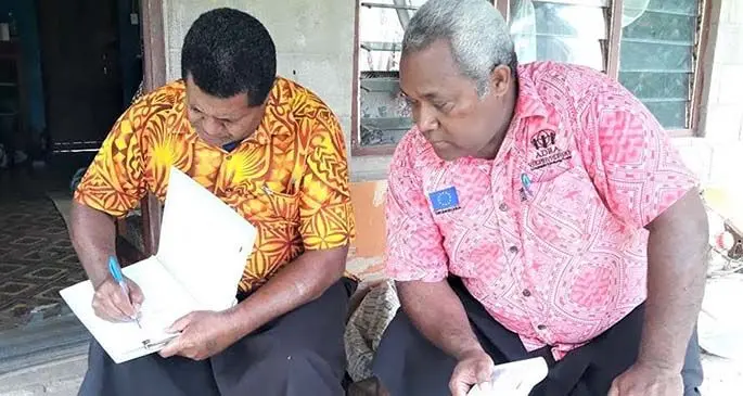Turaga ni Koro of Dawa Village, Mitieli Raisele (left) assisted by Adventist Development Relief Agency Fiji project officer, Anare Drauna during the accountability and monitoring training in the village of Cakaudrove Province on August 20,2020. Photo: Supplied