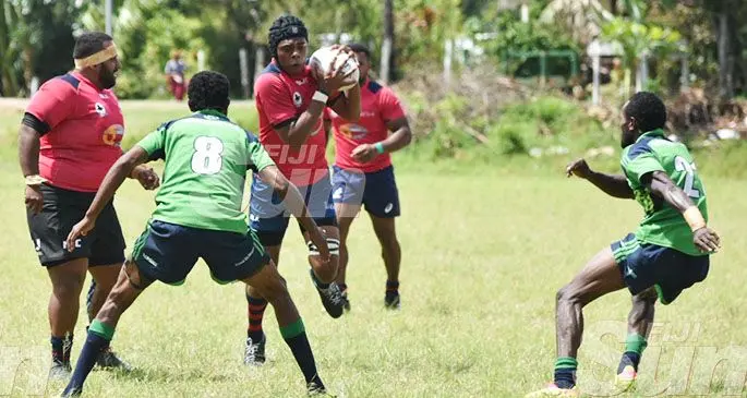 Jone Drova (with ball) of Davujukia Reds tries to break the Nokonoko-Waicoba Crusaders defence during the Nadroga Rugby Union franchise competition at Kalevu Ground in Cuvu, Sigatoka on January 11, 2019. Photo: Waisea Nasokia