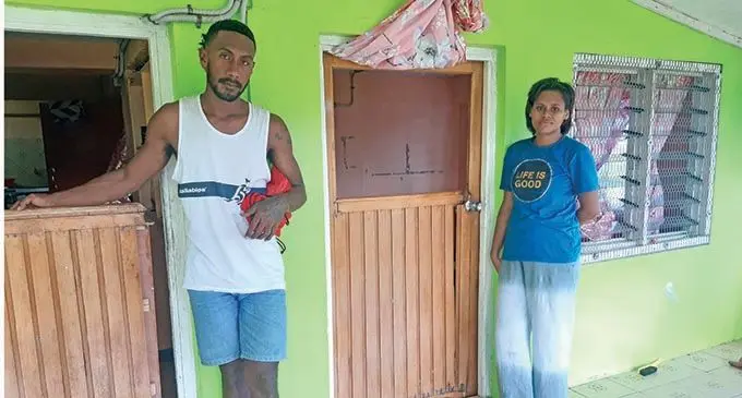 Lepani Koroimoce (left), was one of the men assaulted on Monday evening. Eseta Yavuvatu (right standing by the damaged door to her flat). Photo: Shalveen Chand
