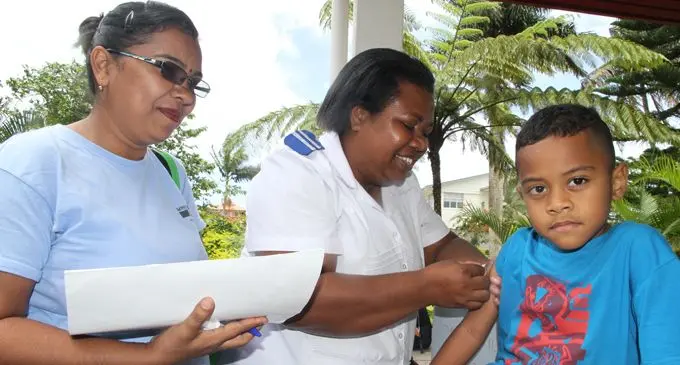 Samabula Health Center staff Nurse Shashi Lata (left) and Taina Marisela while giving measles immunization shot to 5 year-old Dick Bogidrau during their month long house to house call for measles immunization. Photo: Ronald Kumar.
