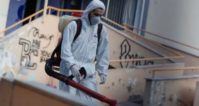 A man wearing a protective suit decontaminates a primary school where a child was diagnosed with coronavirus in Thessaloniki, Greece, Feb. 27, 2020.(Photo by Dimitris Tosidis/Xinhua)