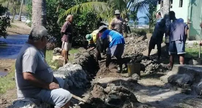 Men from Natawa Village using whatever resources is available to rebuild a village seawall.