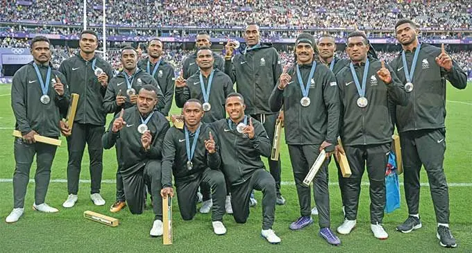 Fiji men’s rugby sevens players with their Paris Olympic Games silver medals at the Stade de France on July 28, 2024. Standing (left-right) Kaminieli Rasaku, Iosefo Masi, Filipe Sauturaga, Ioane Teba, Sevuloni Mocenacagi, Jerry Tuwai (captain), Joseva Talacolo, Selestino Ravutaumada, Jeremaia Matana, Jioji Nasova and Ponipate Loganimasi. Kneeling (left-right) Josua Raisuqe, Waisea Nacuqu and Terio Tamani. Photo: AFP
