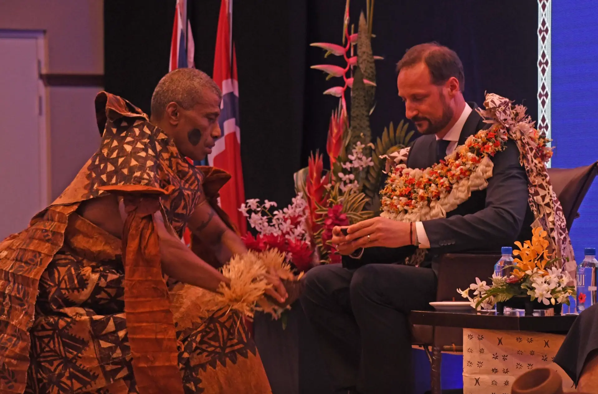 The Prince of Norway receives a bowl of kava during the traditional ceremony of welcome.