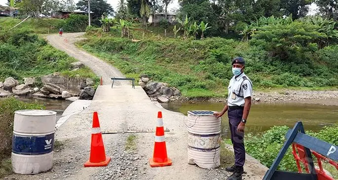 A Police Officer at the Namulomulo Village entrance. Photo: Mereleki Nai