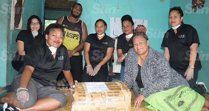 Lal Patel Bale Lawyers staff (from left) Asena Vole, Kya Lal, Nora Vaise, Lily Ali and Elenoa Qalo with Ulavia Tawake, 46, and her son Maikeli Naqarase, 23, after handing the food ration pack to the family on April 30, 2020. Photo: Ronald Kumar