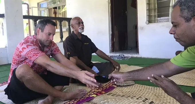 Tourism Fiji chief executive officer, Brent Hill, accepts a bowl of kava, as the Momo Na Tui Nadi, Ratu Vuniani Navuniuci looks on during the i-sevusevu presentation in Narewa, Nadi. Photo: Tourism Fiji.