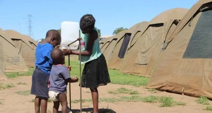 Homeless children wash their hands using the Tippy-Tap hand-washing techniques outside temporary tents in Windhoek, Namibia, April 14, 2020. The Tippy-Tap is a common practice in informal settlements where people do not have access to running water. The technique is strongly advised as an attempt to assist the Namibian government with its lockdown efforts in the fight against the COVID-19 pandemic. (Xinhua/Jacobina Mouton)