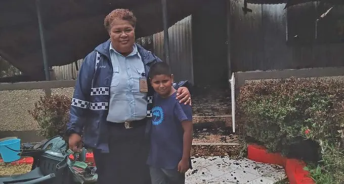 Police Corporal Akeneta Sautaki with nine-year-old Pranav Kumar Deo in front of his home that was destroyed in a Fire at Raviravi, Ba on December 29, 2022. Photo: Fiji Police Force
