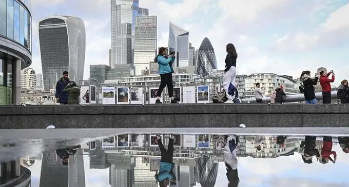 People are seen in front of buildings in the City of London, London, Britain, on Feb. 1, 2020. (Photo by Stephen Chung/Xinhua) 
