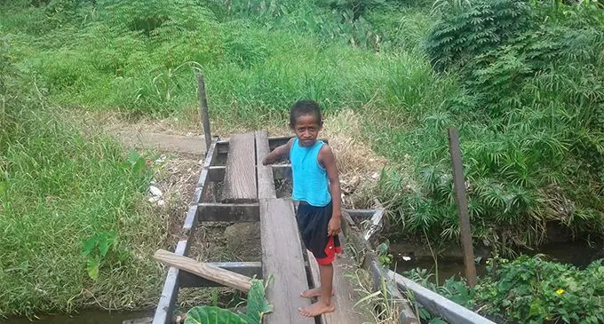 Esala Vunakece, 6, standing on the broken bridge at RL Sharma Road Nadera.  Photo: Shirika Shalini