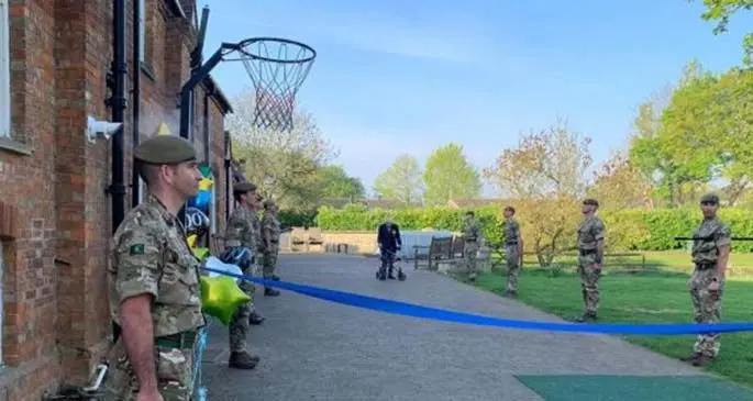 Tom Moore(C), a retired civil servant and Second World War veteran, walks his final lap at his garden as soldiers of the Yorkshire Regiment stand aside in Bedfordshire, Britain, on April 16, 2020. (Photo by Frances Haycock/MOD/Handout via Xinhua)